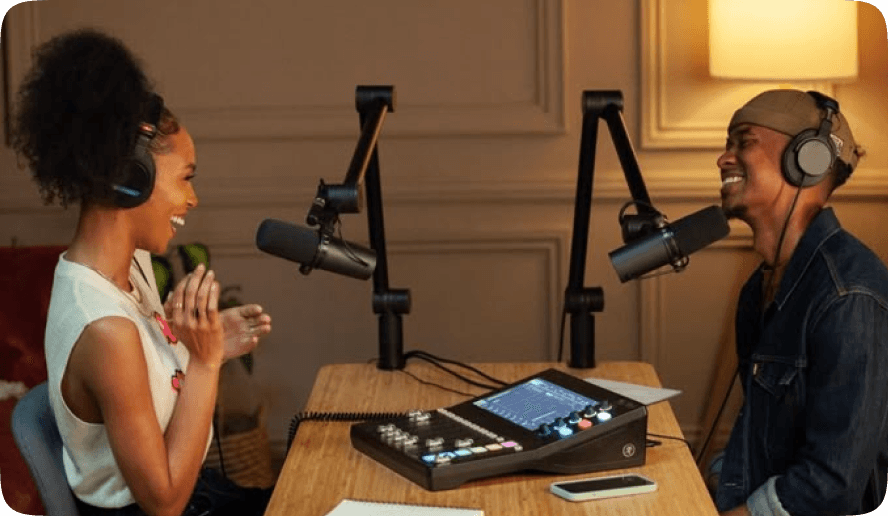 Two hosts recording with a podcast mixer